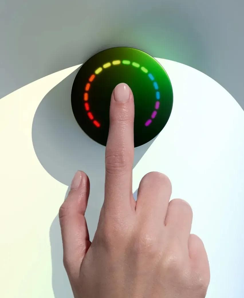 A fingertip resting on the Prysm iO scanner as its light ring displays a reading